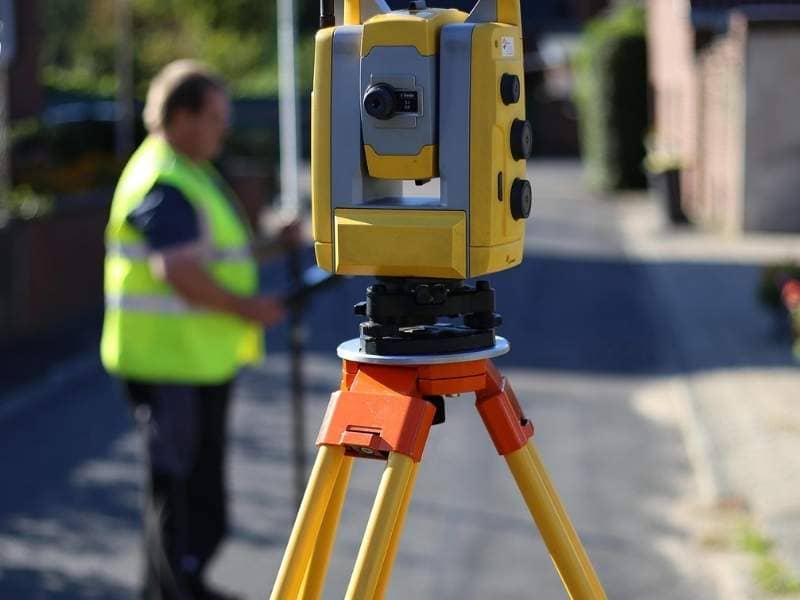 Land surveyor using total station equipment during property boundary fieldwork in Grand Prairie Texas