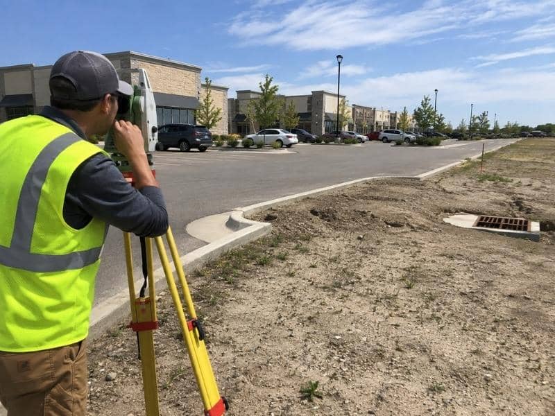 Topographic Survey crew measuring elevations for a commercial parking expansion in Grand Prairie TX